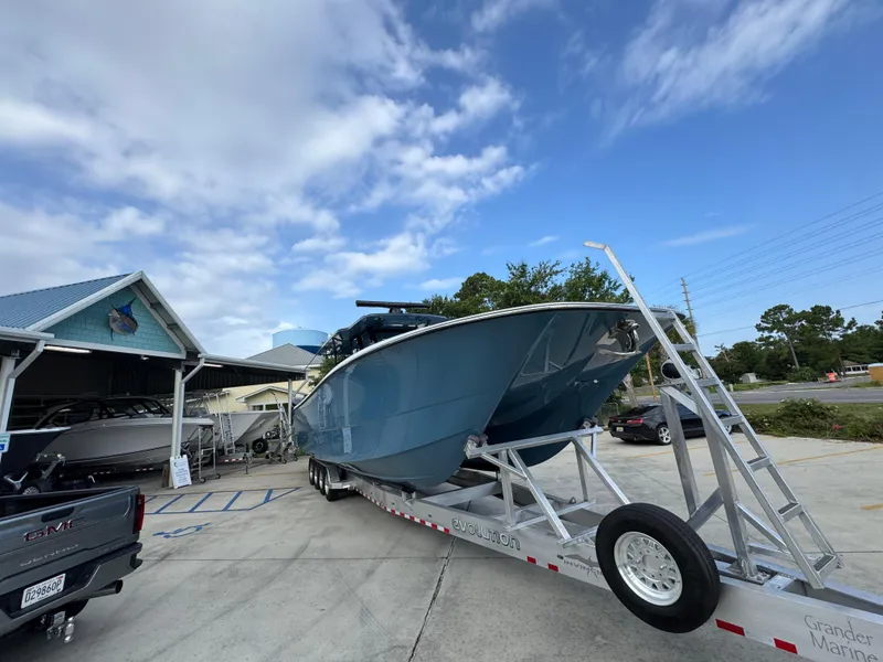 Slide: The Image of 2026 Invincible 46 Catamaran on trailer at marina, under blue sky. - 8