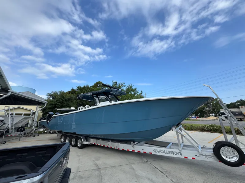 Slide: The Image of 2026 Invincible 46 Catamaran on trailer, parked outdoors under a clear blue sky. - 9