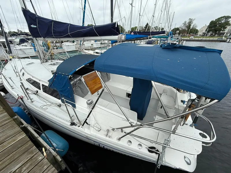 Slide: The Image of 2000 Catalina 36 MkII sailboat docked, featuring blue canvas covers and sleek design. - 2
