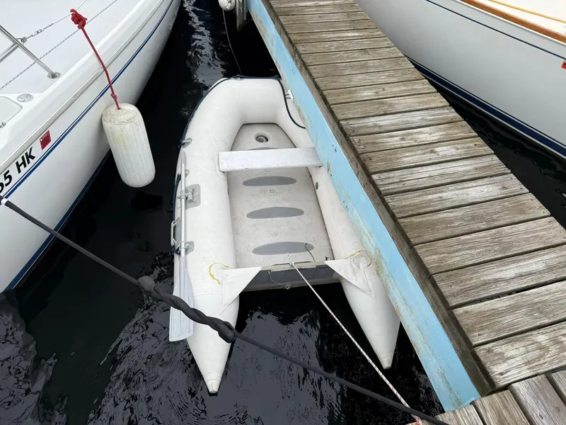 Slide: The Image of Inflatable dinghy docked beside a Catalina 36 MkII sailboat, 2000 model, at a wooden pier. - 20