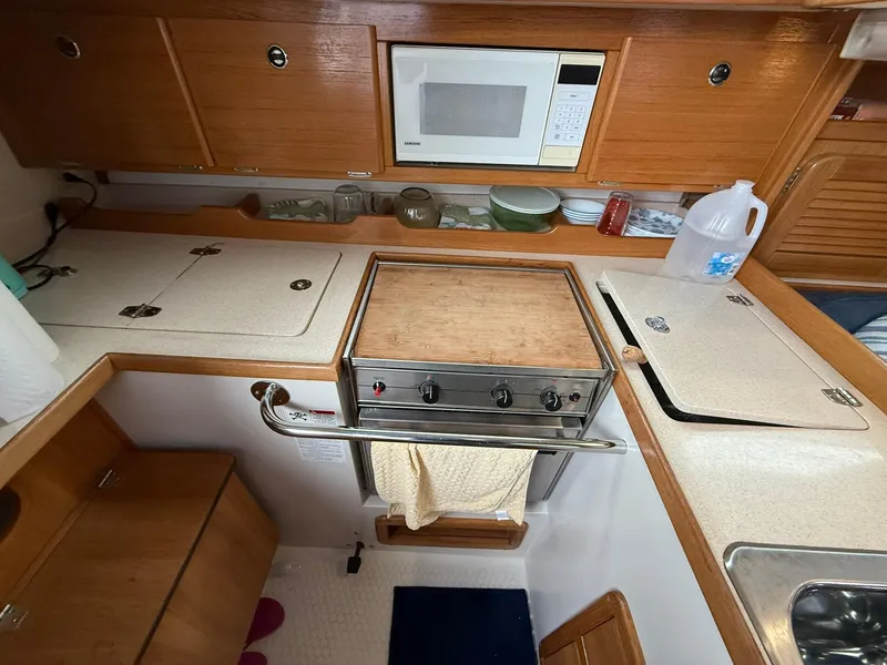 Slide: The Image of Catalina 36 MkII 2000 yacht kitchen with stove, microwave, and storage cabinets. - 33