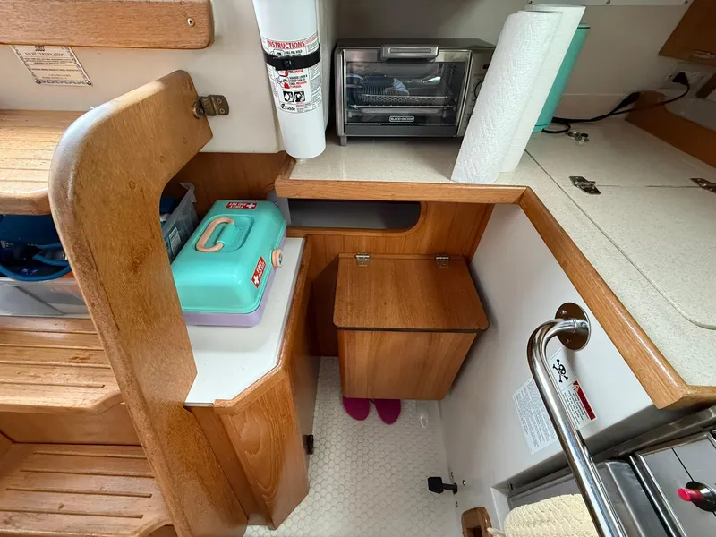 Slide: The Image of Interior of 2000 Catalina 36 MkII sailboat with wooden cabinetry and compact kitchen area. - 37