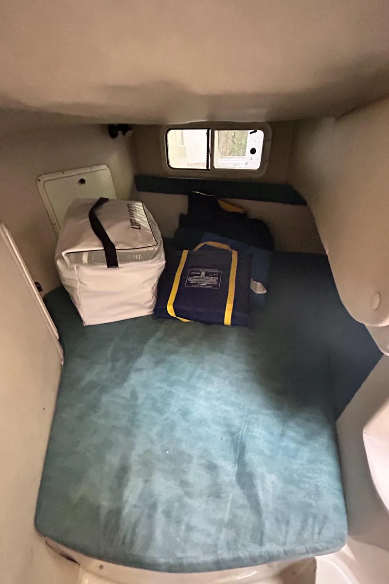 Slide: The Image of Interior cabin of a 1995 Donzi 255 Medallion boat with storage and bedding. - 10