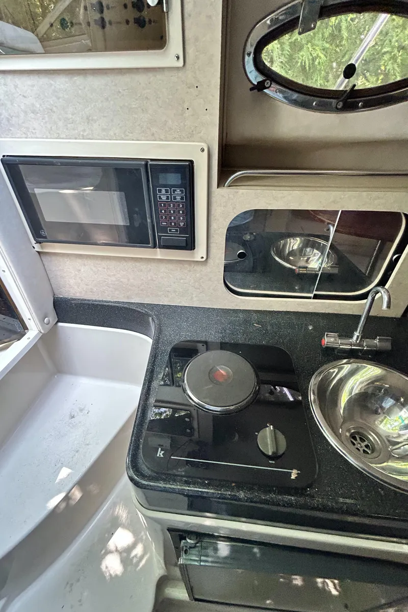 Slide: The Image of 1995 Donzi 255 Medallion boat kitchen with microwave, stove, and sink. - 12