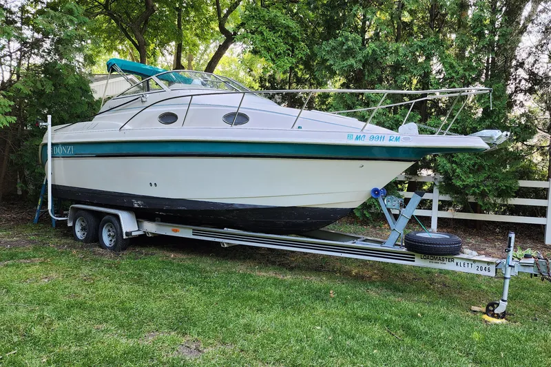 Slide: The Image of 1995 Donzi 255 Medallion boat on a trailer in a grassy area. - 18