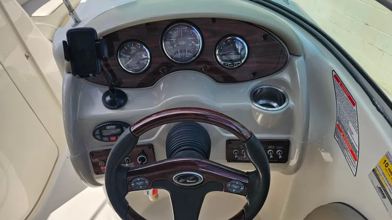 Slide: The Image of 2005 Sea Ray 220 Sundeck dashboard with gauges, steering wheel, and controls. - 10