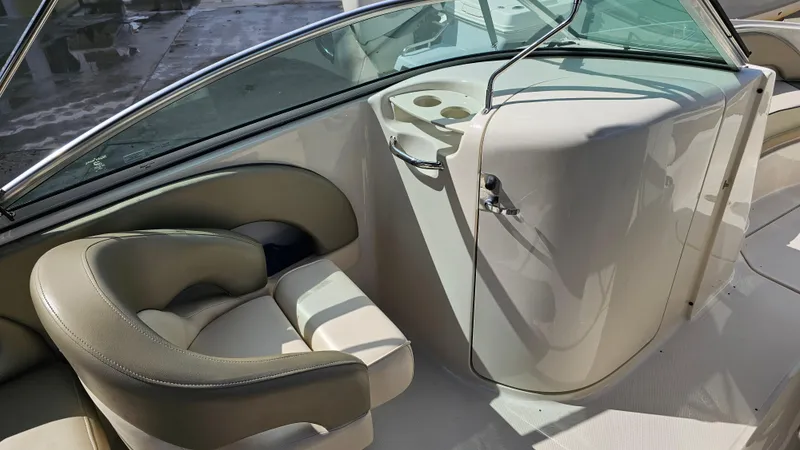 Slide: The Image of 2005 Sea Ray 220 Sundeck interior with beige seating and cup holders. - 12