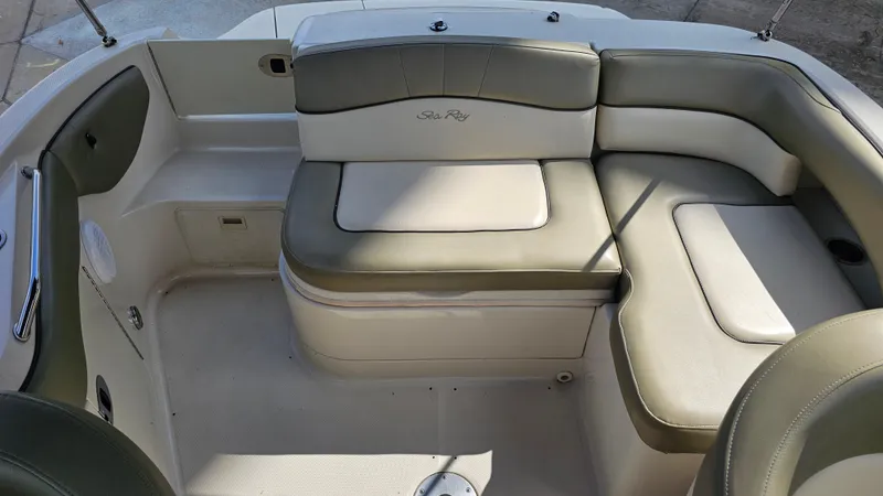 Slide: The Image of 2005 Sea Ray 220 Sundeck interior with cushioned seating and storage compartments. - 19