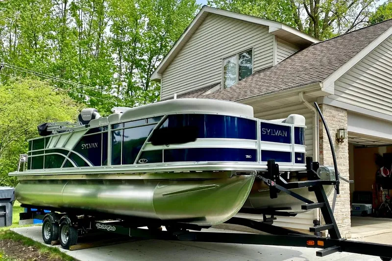 Slide: The Image of 2022 Sylvan L3 Party Fish pontoon boat on trailer in driveway. - 14
