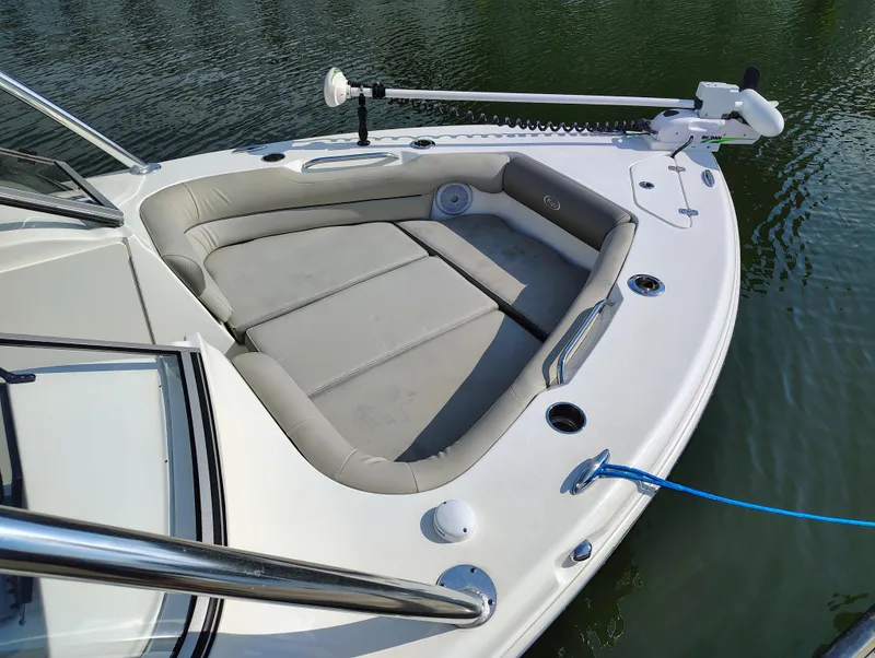 Slide: The Image of 2023 Key West 239 DFS boat with cushioned seating and trolling motor on calm water. - 1
