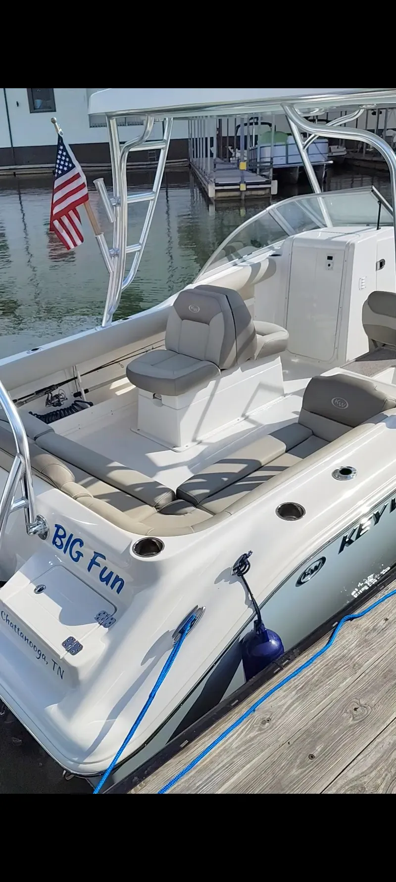 Slide: The Image of 2023 Key West 239 DFS boat docked, featuring comfortable seating and an American flag. - 10