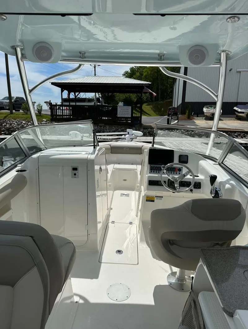 Slide: The Image of 2023 Key West 239 DFS boat interior with steering wheel and seating. - 11