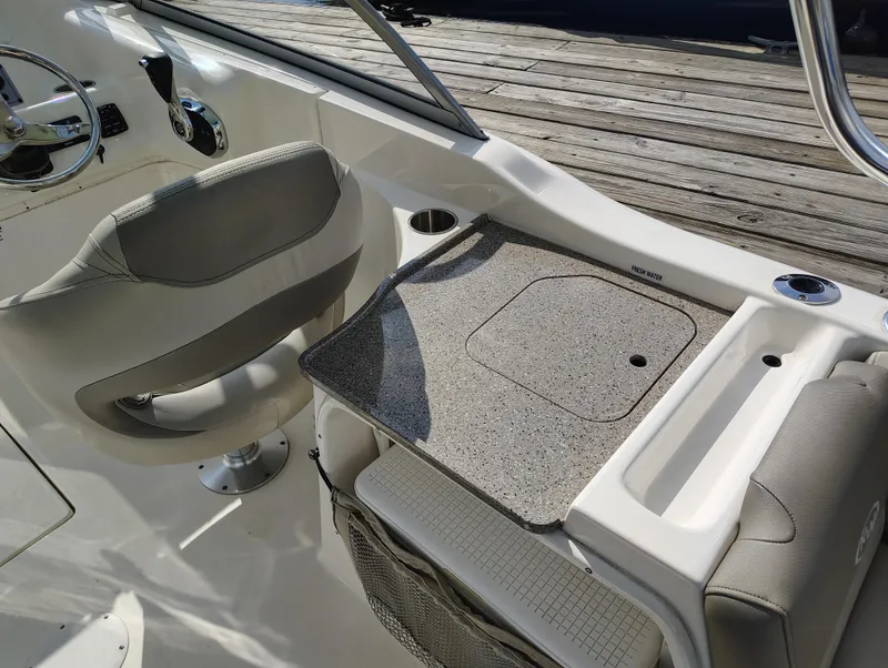 Slide: The Image of 2023 Key West 239 DFS boat interior with helm, seating, and storage compartments. - 17