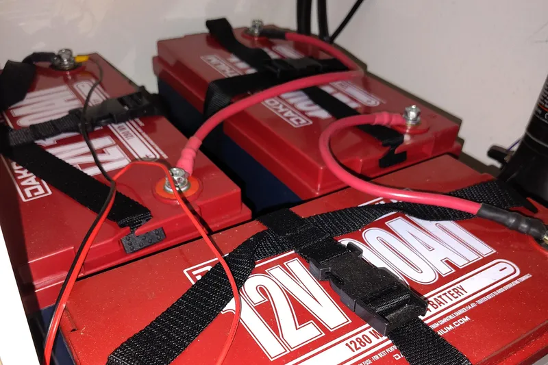 Slide: The Image of Red 12V boat batteries with cables in a 2023 Key West 239 DFS. - 29