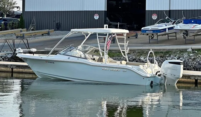 Slide: The Image of 2023 Key West 239 DFS boat docked, featuring a sleek design and Suzuki outboard motor. - 33