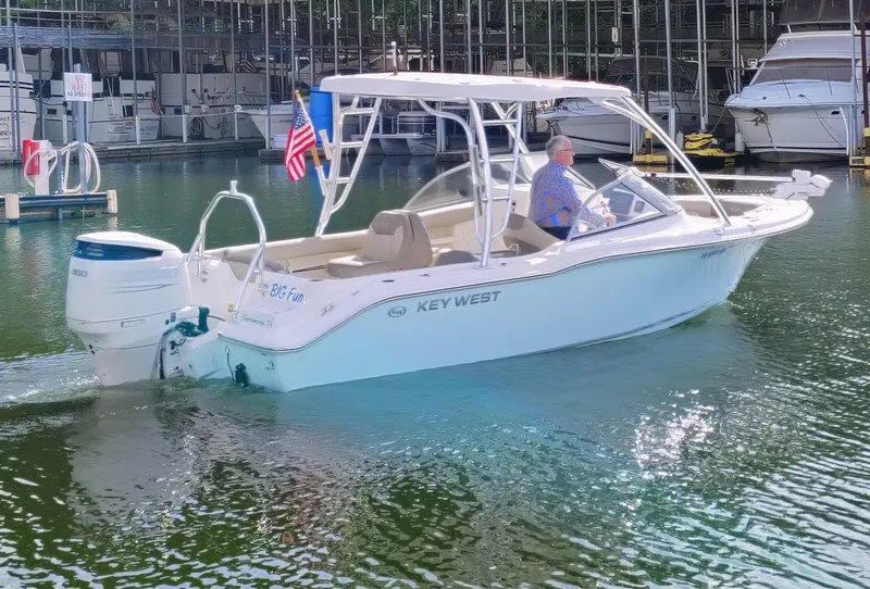 Slide: The Image of 2023 Key West 239 DFS boat on water, American flag, marina background. - 6