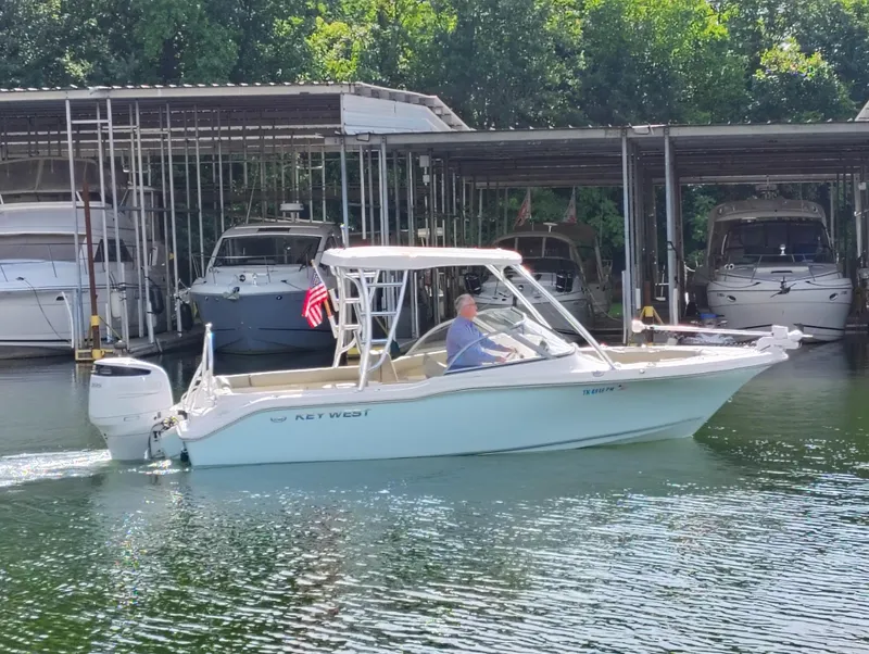 Slide: The Image of 2023 Key West 239 DFS boat cruising near marina with American flag. - 7