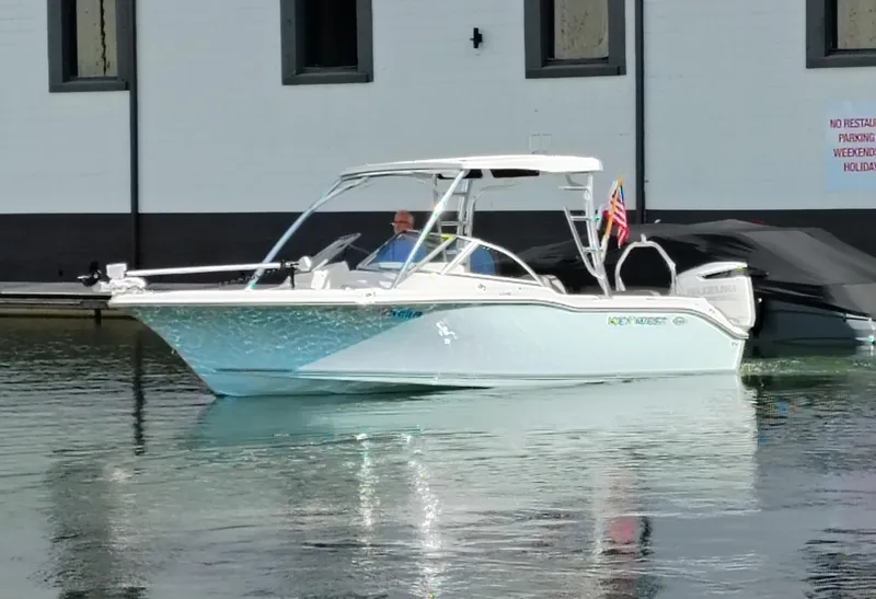 Slide: The Image of 2023 Key West 239 DFS boat docked on calm water, featuring sleek design and American flag. - 9
