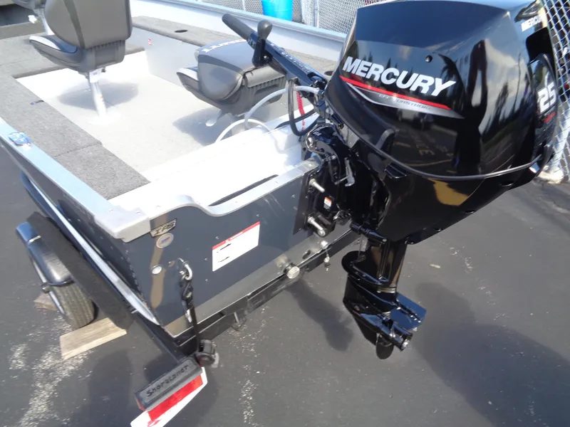 Slide: The Image of 2025 Lund 1400 Fury Tiller boat with Mercury 25 HP outboard motor, parked on trailer. - 3