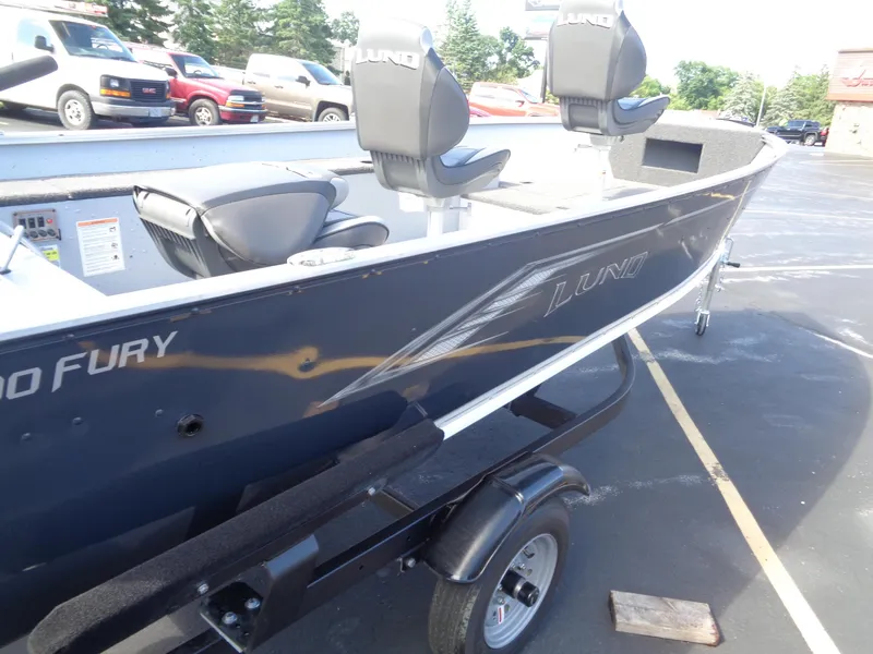 Slide: The Image of 2025 Lund 1400 Fury Tiller boat on trailer, featuring sleek design and comfortable seating. - 5