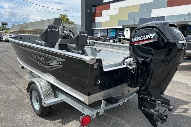 Slide: The Image of 2025 Lund 1875 Alaskan SS boat with Mercury engine on trailer, parked outdoors. - 3