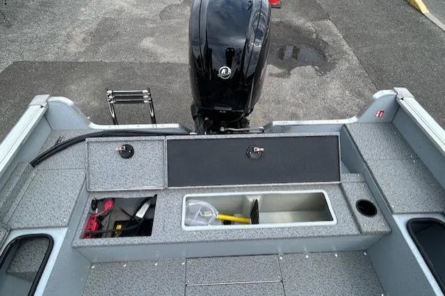 Slide: The Image of 2025 Lund 1875 Alaskan SS boat interior with storage compartments and outboard motor. - 7