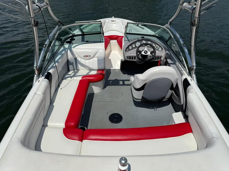 Slide: The Image of 2001 MasterCraft X-Star boat interior with red and white seating, steering wheel, and dashboard on water. - 10
