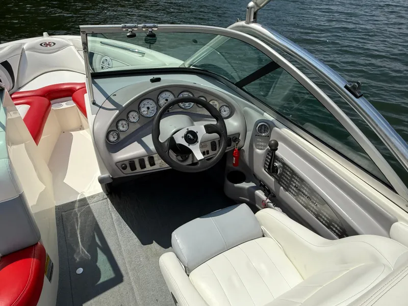 Slide: The Image of 2001 MasterCraft X-Star boat interior with steering wheel and dashboard, on a sunny day. - 13