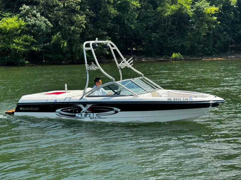Slide: The Image of 2001 MasterCraft X-Star boat on a lake, surrounded by lush greenery. - 2