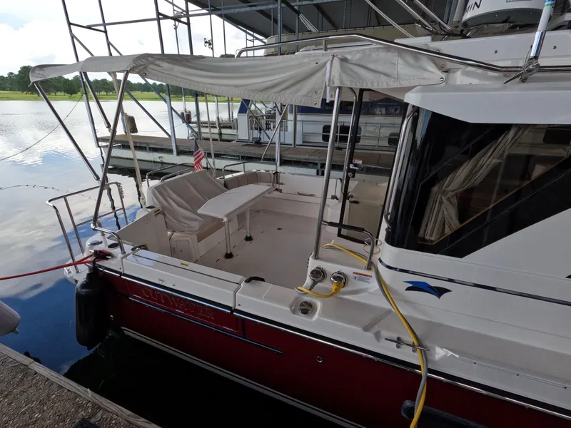 Slide: The Image of 2020 Cutwater C-30 Sedan boat docked, featuring a covered seating area and American flag. - 12