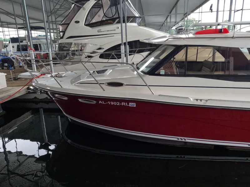 Slide: The Image of 2020 Cutwater C-30 Sedan boat docked in a marina, featuring a sleek red and white design. - 2
