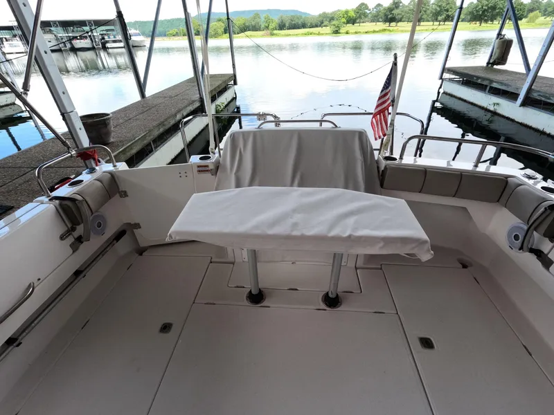 Slide: The Image of 2020 Cutwater C-30 Sedan boat interior with covered seating, docked by a serene lake. - 23