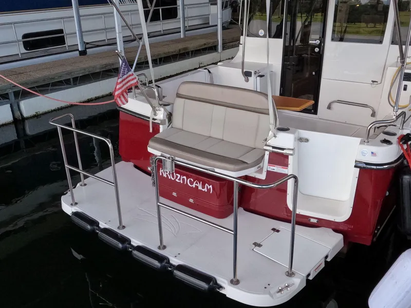 Slide: The Image of 2020 Cutwater C-30 Sedan boat with seating and American flag at dock. - 25