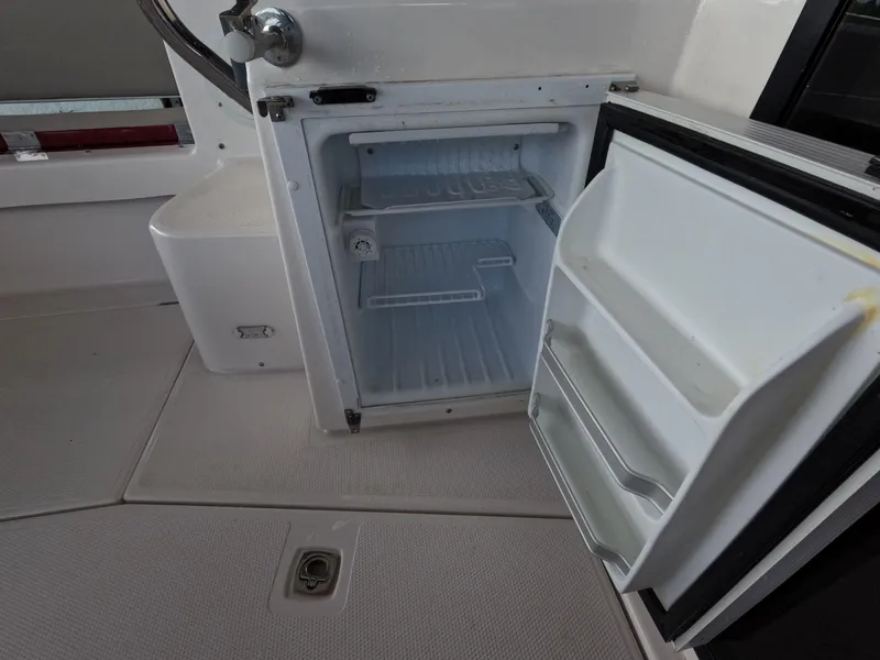 Slide: The Image of Open refrigerator on 2020 Cutwater C-30 Sedan boat, showing empty shelves and door compartments. - 29
