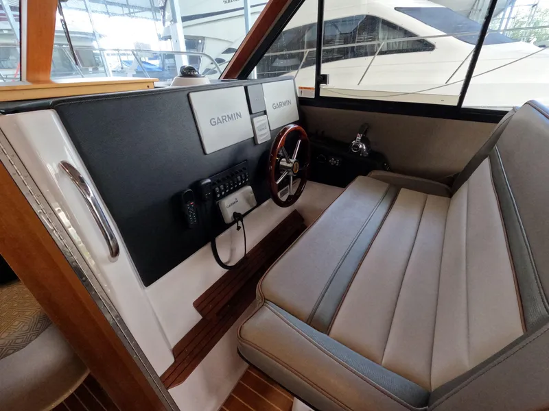 Slide: The Image of 2020 Cutwater C-30 Sedan helm with Garmin navigation, featuring a sleek steering wheel and comfortable seating. - 37