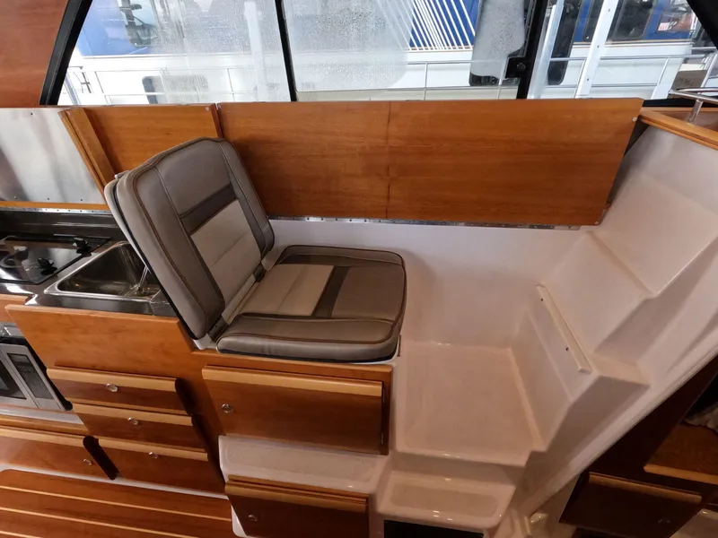 Slide: The Image of 2020 Cutwater C-30 Sedan interior with seating, sink, and wooden cabinetry. - 49