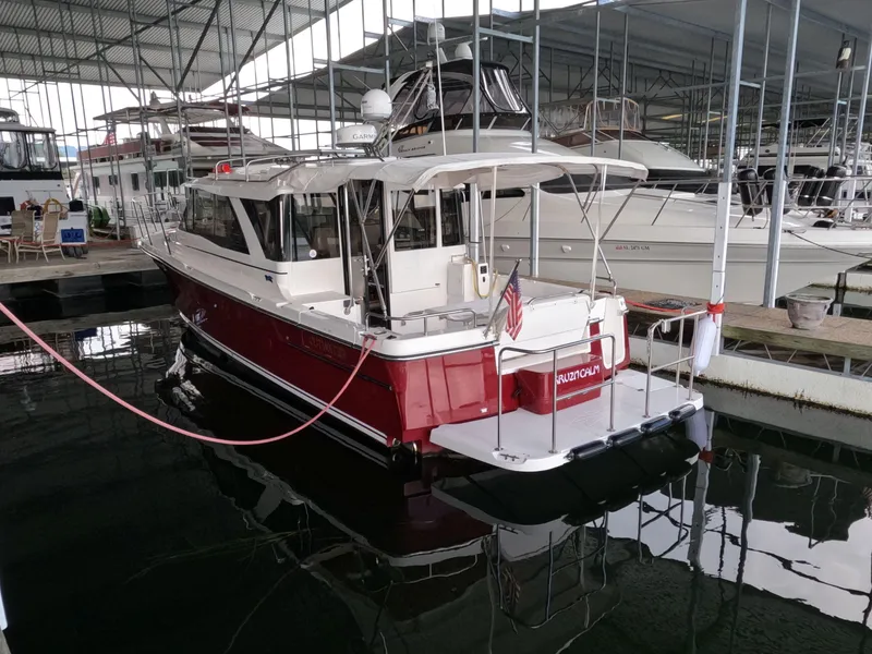 Slide: The Image of 2020 Cutwater C-30 Sedan boat docked in a marina, featuring a red and white exterior. - 5
