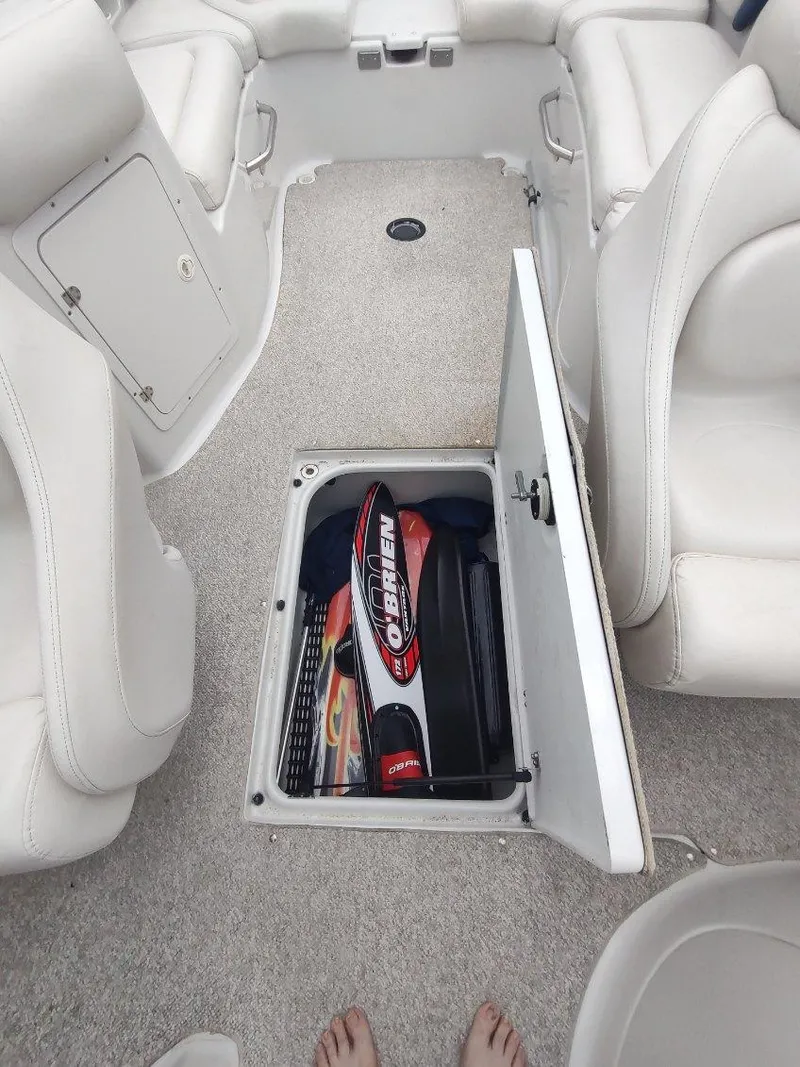 Slide: The Image of 2005 Crownline 270 BR boat interior with open storage compartment containing water sports equipment. - 11