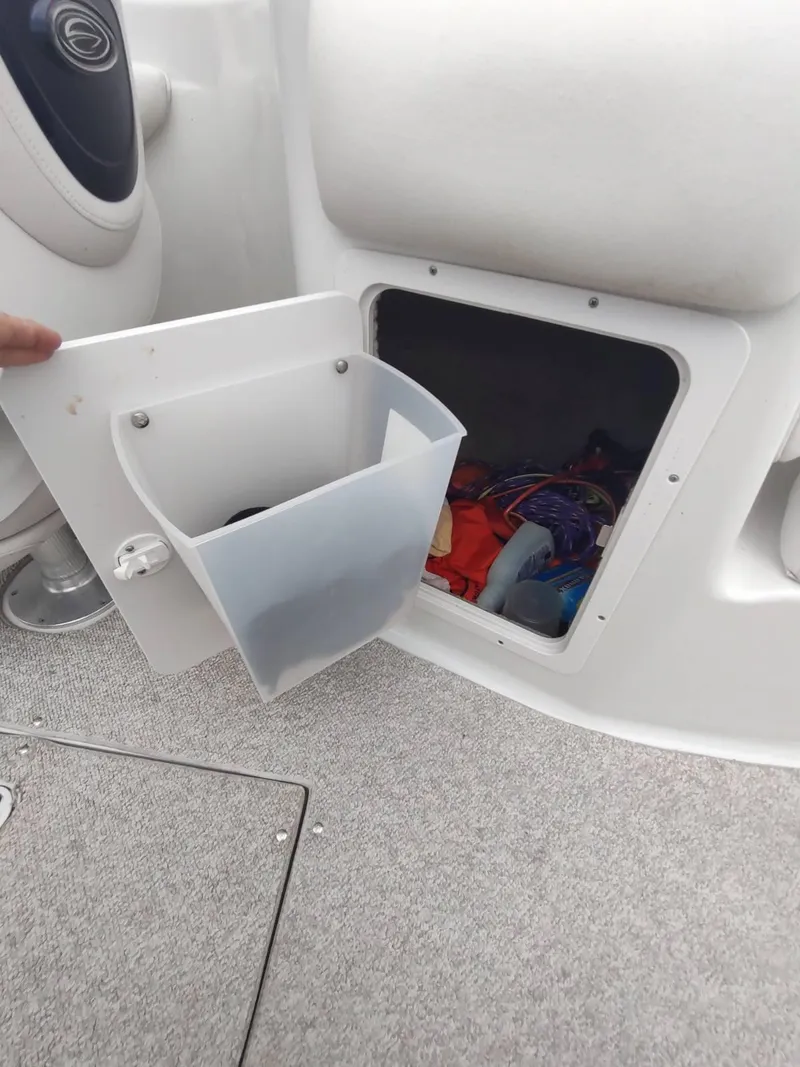 Slide: The Image of Storage compartment on a 2005 Crownline 270 BR boat, open with visible contents. - 13