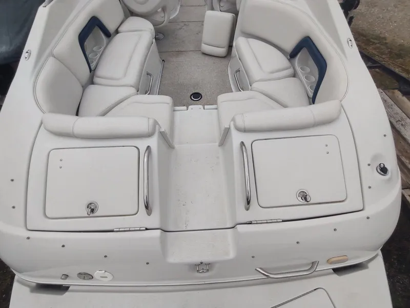 Slide: The Image of 2005 Crownline 270 BR boat interior with white seating and storage compartments. - 14