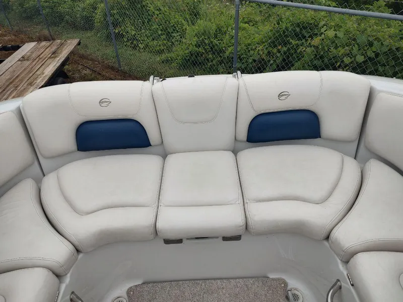 Slide: The Image of 2005 Crownline 270 BR boat interior with white and blue cushioned seating. - 2