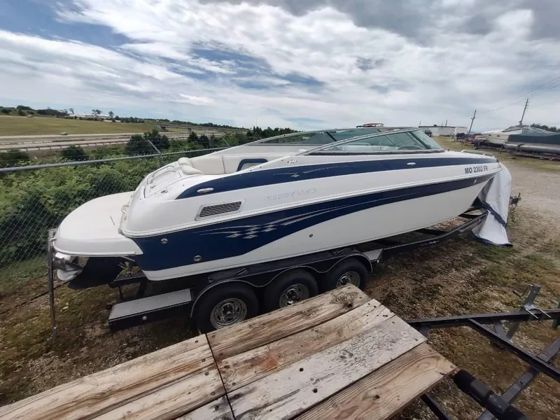 Slide: The Image of 2005 Crownline 270 BR boat on trailer, parked outdoors under cloudy sky. - 26