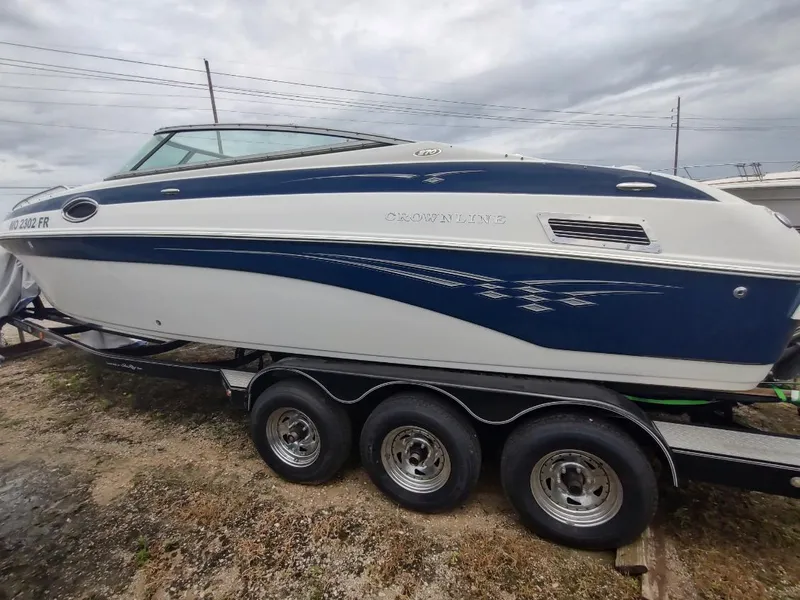 Slide: The Image of 2005 Crownline 270 BR boat on trailer, blue and white design, parked outdoors. - 27