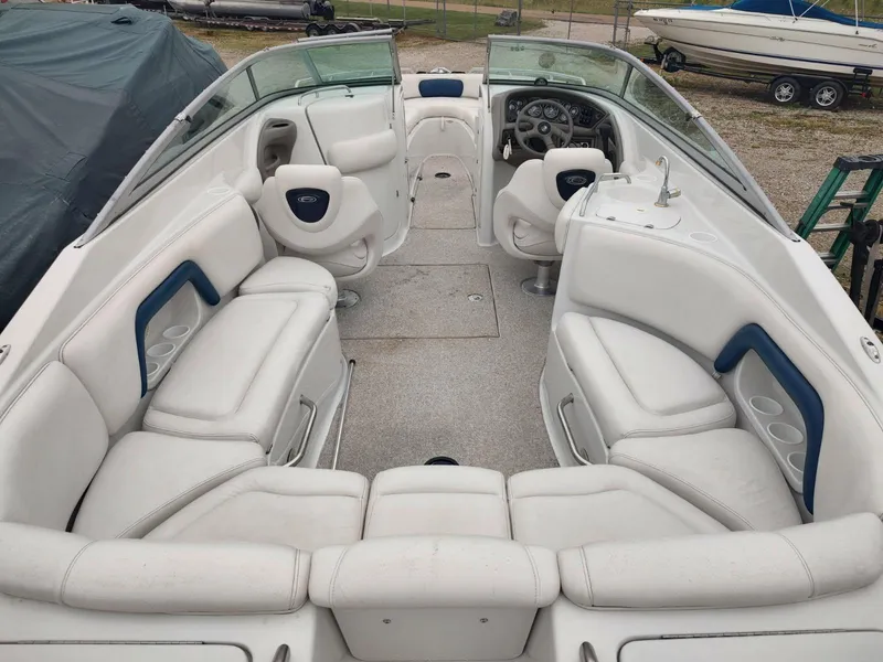 Slide: The Image of 2005 Crownline 270 BR boat interior with white seating and steering wheel. - 30