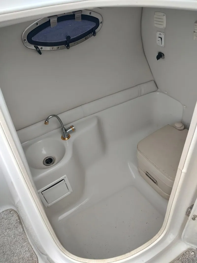 Slide: The Image of 2005 Crownline 270 BR boat interior with sink and portable toilet. - 7