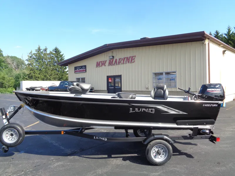 The Image of 2025 Lund 1400 Fury Tiller boat on trailer outside MW Marine building. - 0