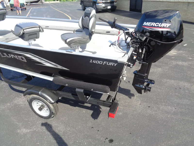 Slide: The Image of 2025 Lund 1400 Fury Tiller boat with Mercury outboard motor on a trailer. - 6