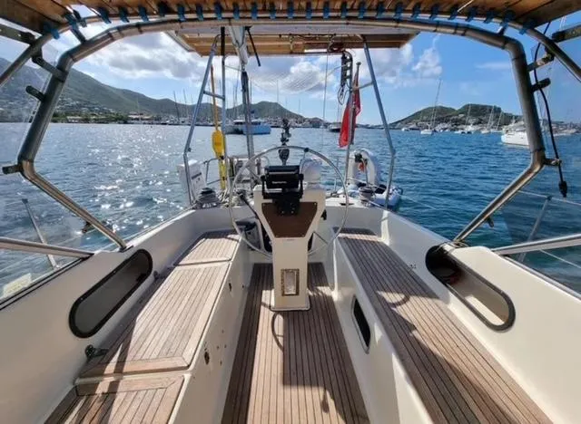 Slide: The Image of Cockpit view of 1990 Maxi 35 CC sailboat on a sunny day, docked in a scenic harbor. - 12