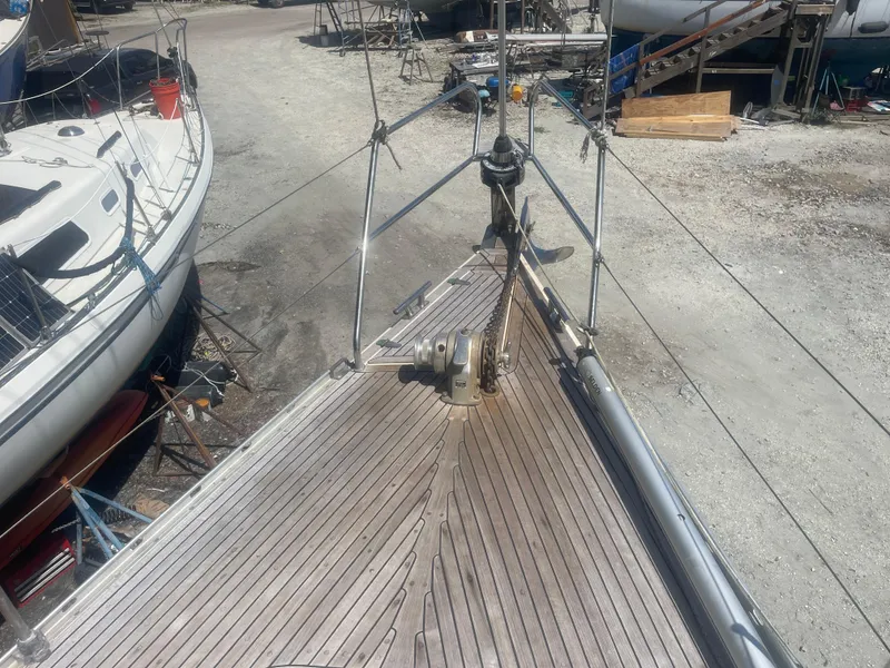 Slide: The Image of Bow view of a 1990 Maxi 35 CC sailboat on dry dock, showcasing deck and anchor. - 13