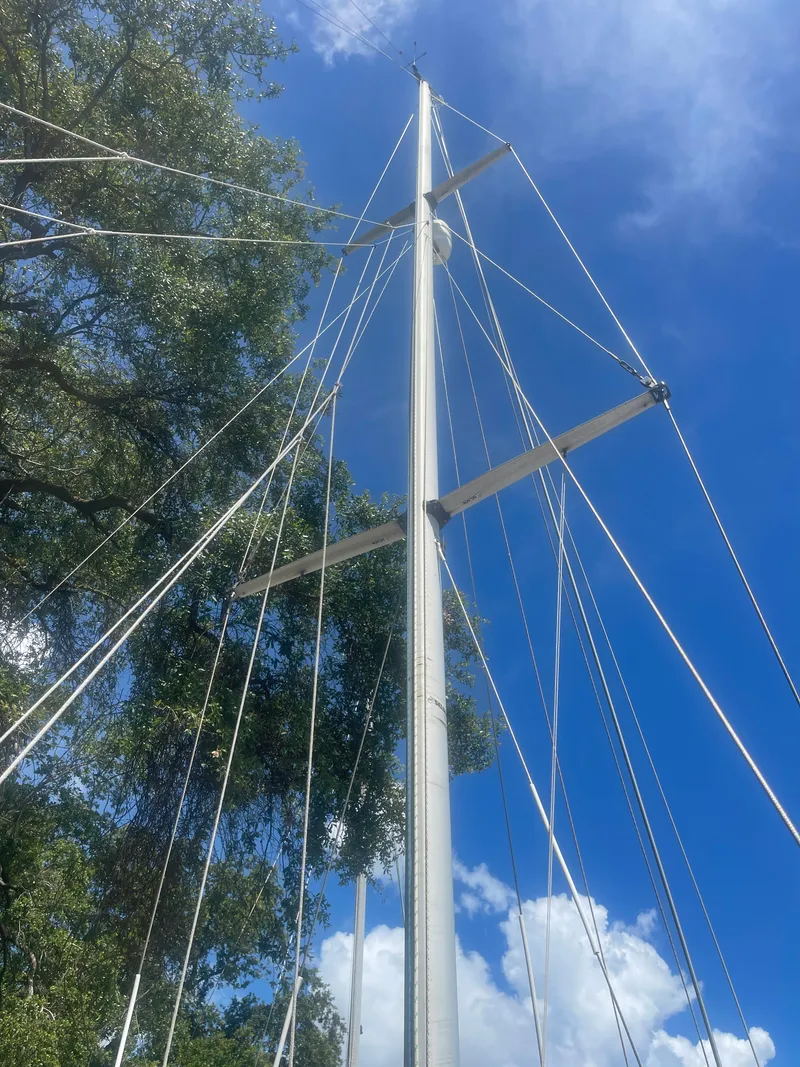 Slide: The Image of Sailboat mast of 1990 Maxi 35 CC against blue sky and tree background. - 17